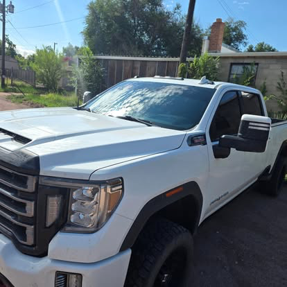 White GMC Sierra HD with tinted windows and windshield strip