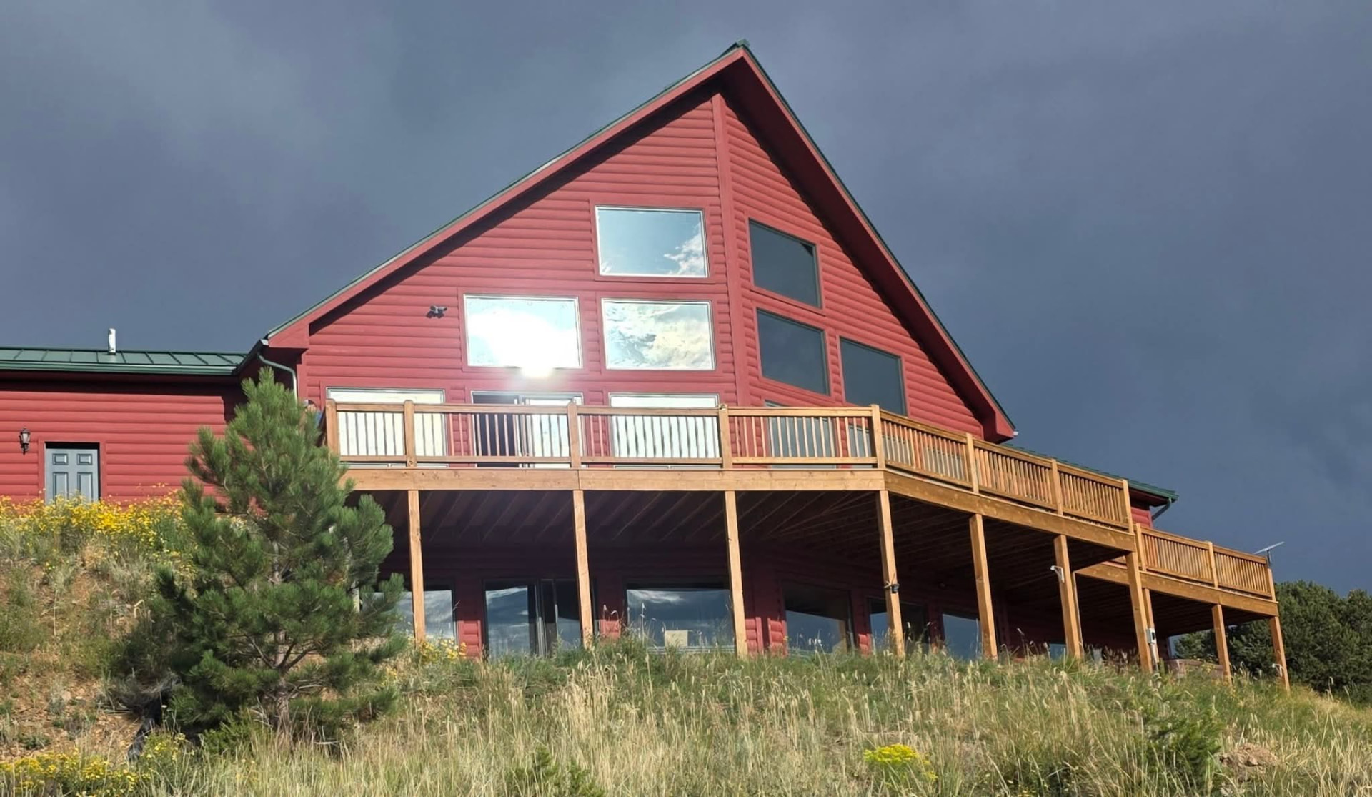 Red mountain home with tinted upper gable and deck windows