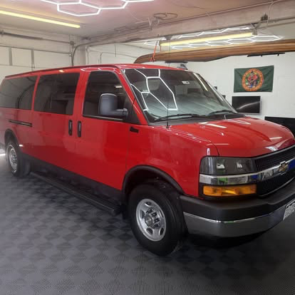 Red Chevrolet Express van tinted in the Cañon City shop bay