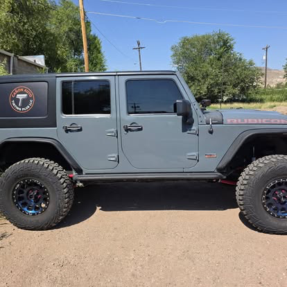 Gray Jeep Wrangler Rubicon with tinted windows and Canon Auto Tinting Plus decal