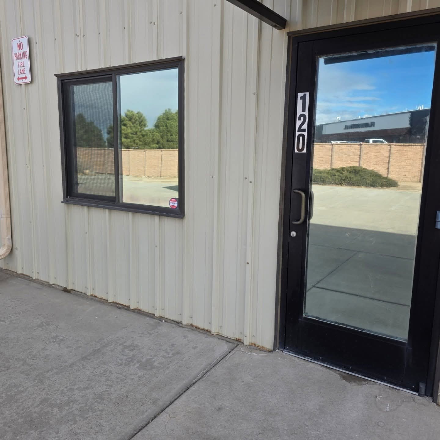 Tinted office window and entry door on a Cañon City shop building